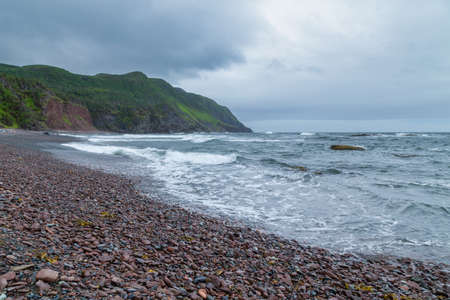 A rocky beach next to rough ocean water - Gros Morne, Newfoundland, Canada.の写真素材