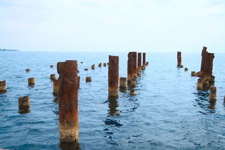 The old rusty iron bridge on seaの写真素材