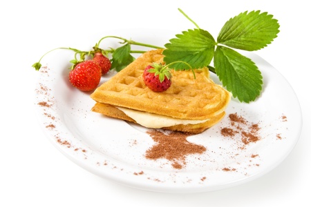 Plate of belgian waffles with fresh strawberries and whipped creamの写真素材