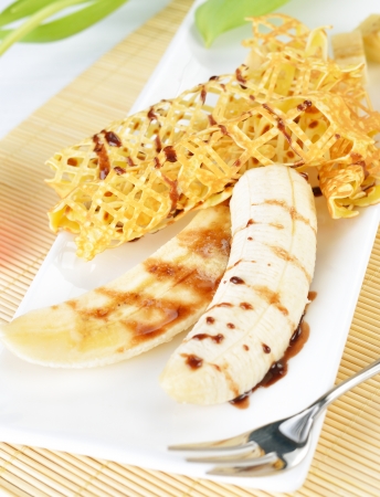 closeup image of a delicious pancakes with banana and chocolate syrup on itの写真素材