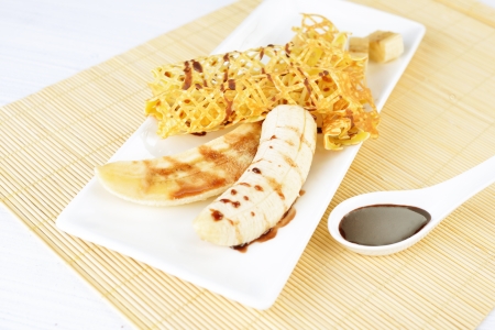 delicious pancakes with banana and chocolate syrup on itの写真素材