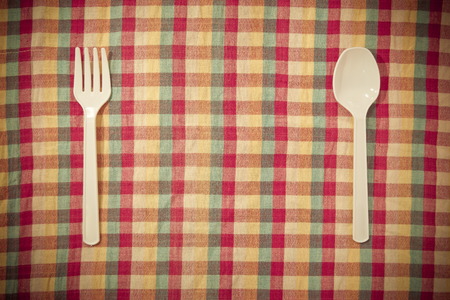Plastic fork and spoon on the tableclothsの写真素材