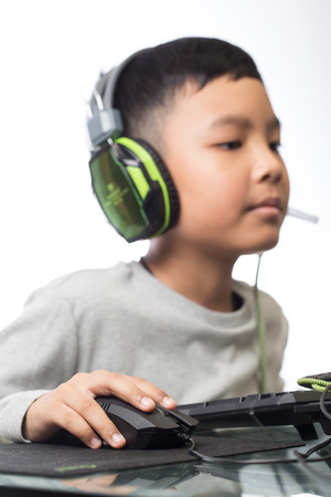 Close up on right hand for clicking over mouse by gamer kid (Selective focus on hand)