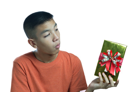 Young asian teenager wondering what in the box on white backgroundの写真素材