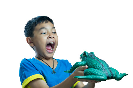 Asian kid holding toy frog and look very scareの写真素材
