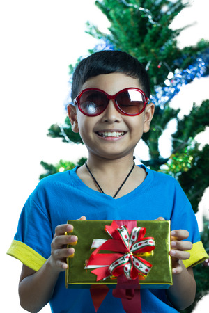 Asian kid wearing sunglass and hold small present boxの写真素材