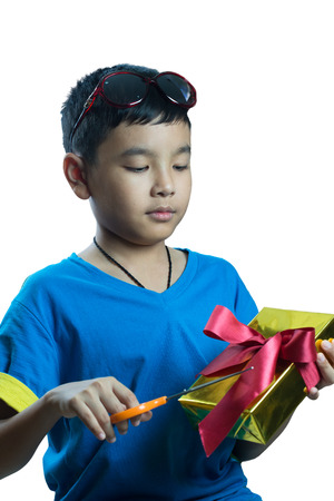 Asian kid try to open his present with scissorの写真素材