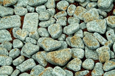Pattern of grey pebbles laid over sand base