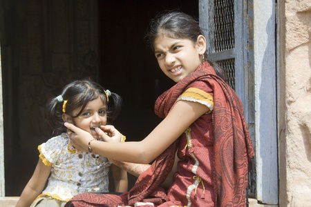 Playful, naughty bite from mischievous younger sisterの写真素材