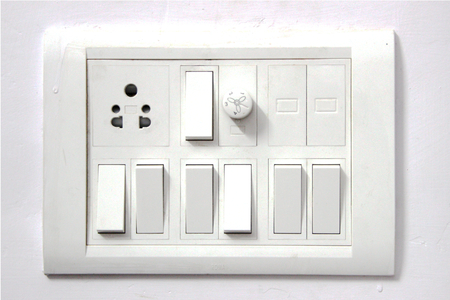 White electrical switch board panel on white concrete wall