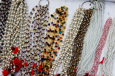 Display of variety of colorful, white and transparent beaded necklaces