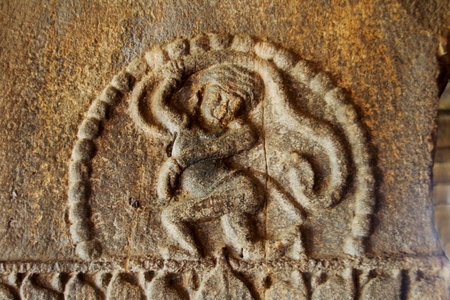 Stone pillar sculpture of man running terrified by chasng snake at Ladkhan Temple in Aihole, Karnataka, India, Asiaのeditorial素材