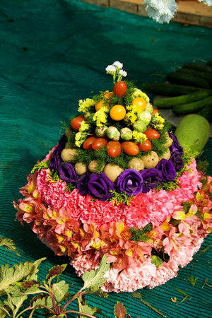 View of cone decoration arrangement made up of flowers and vegetablesの写真素材