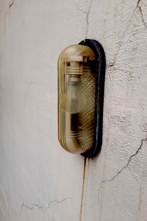 View of wall mounted electrical bulb bracket with glass shield for rain protection
