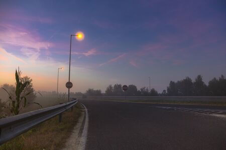 Highway without cars, light lanterns and pink gentle sky at dawn