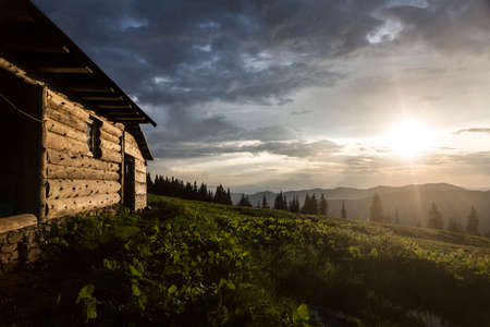 Evening sunbeams shine on a wooden house in the mountains. Carpathians, Marmaroshchyna, Maramures, Ukraineの写真素材