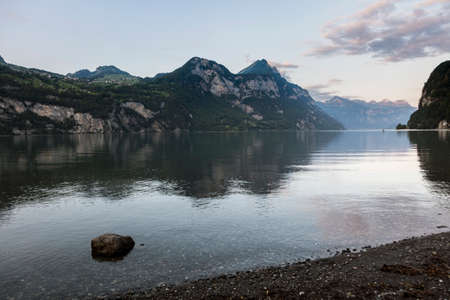 Beautiful alpine sunset view with reflections at the Lake Walensee in Swiss Alps, Switzerland