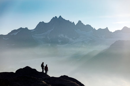 Profiles of two people photographers in the French Alps against the backdrop of the Mont Blanc massif, Chamonixの写真素材