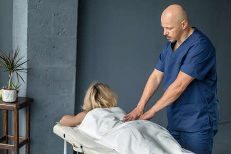 Young beautiful woman having massage in spa salon. Relaxation and treatment on woman backの写真素材