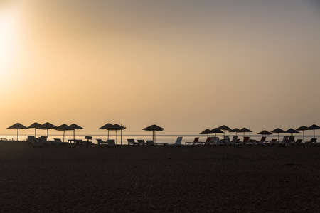 Orrange sunset with sunbeds on a beach, Mediterranean coast of south-west Turkey, Antalya Provinceの写真素材