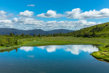 The water surface of a blue lake against the background of the Gorgan mountain range, the...