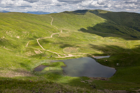 A sunny day in a green mountain meadow with lake, Svydovets, The Carpathians, Ukraine.の写真素材