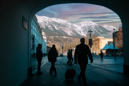 Innsbruck, Austria - 9 Jan, 2020: silhouettes of people and shadows of a tourist with a suitcase in...