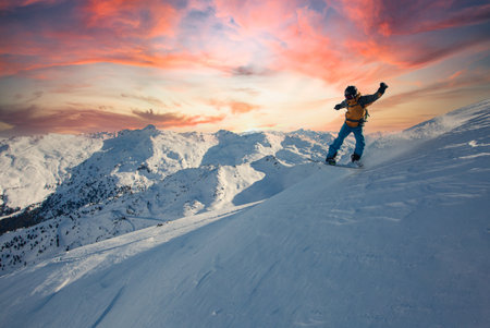 Snowboard rider jumping on a beautiful sunny day in the mountains. Extreme snowboard freeride sport.の写真素材