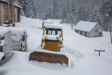 The tractor is covered with a thick layer of snow. The old vehicles are covered in snowのeditorial素材