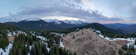 A top view of the spring Carpathian mountains covered with snow from the bird view, Chornohora range...