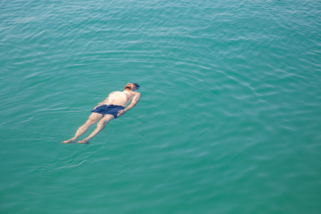 A man floating in the sea, top view. Calm vacation at seaの写真素材