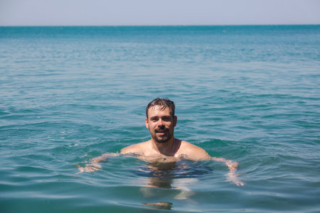A man in the sea is swimming in the water. Calm vacation at seaの写真素材