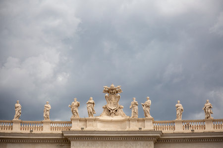 Statues of famous people above the building with columns in the Vatican, Rome, Italyのeditorial素材