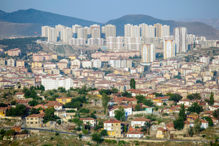 A vibrant panorama of a city nestled against rolling hills, with a mosque standing out. A bustling cityscape with towering skyscrapers and a mix of old and new architecture.の写真素材