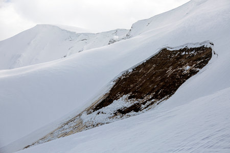 A dangerous reminder: A recent avalanche has exposed a dark patch of earth on a snow-covered...