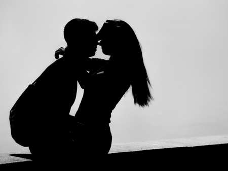 silhouette of a boy and a girl who hug each other tenderlyの写真素材