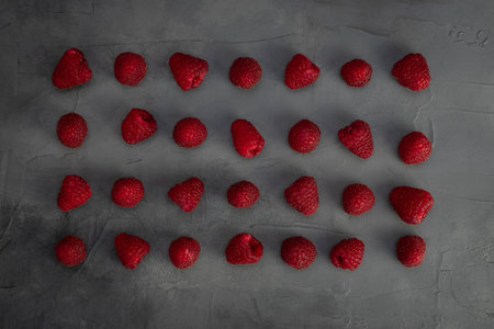 Raspberry pattern on gray stone background. Top view. Flat layの写真素材