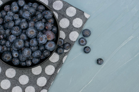 bowl full of blueberries on mint stone background. Fresh berries.