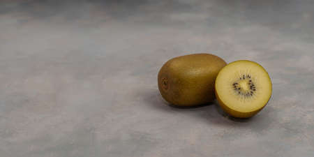 Ripe whole kiwi fruit and half kiwi fruit on grey table background. Fresh fruits.の写真素材