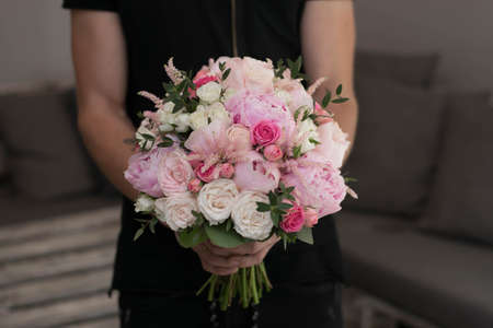 Pink wedding bouquet, composed of roses, freesias, peonies, hypericum, astilba and eucalypthus, isolated on gray stone background.の写真素材