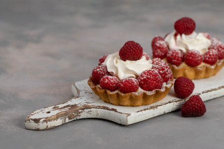 A delicious dessert for the whole family and easy diet, raspberry basket of unleavened dough with a gentle sprinkle with powdered sugar.の写真素材