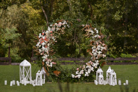 Wedding decor with flowers and candles. This is round arch of foliage and flowers. Outside wedding ceremonyの写真素材