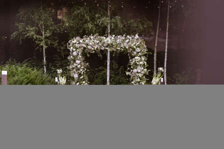 Wedding. Wedding ceremony. Arch. Arch, decorated with white flowers standing in the woods, in the wedding ceremony area. Wedding day.の写真素材