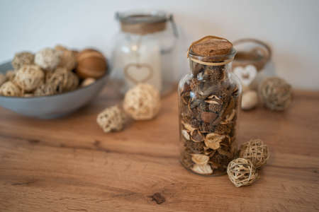 The potpourri in glass bottle on a wood table, provides a relaxing scent and celebration. Wellness concept and self-care background.の写真素材