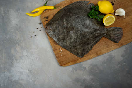 Raw flounder fish with spices. Seafood on a gray stone background. Top view. Free copy space. BIO fish.の写真素材