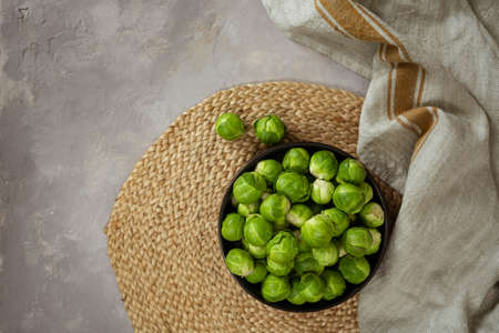 Black bowl with fresh Brussels cabbage on table, top view.の写真素材