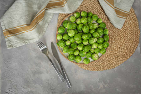 Plate with fresh Brussels cabbage on table, top view.