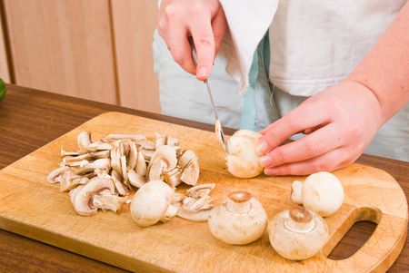 The girl cuts mushroomsの写真素材