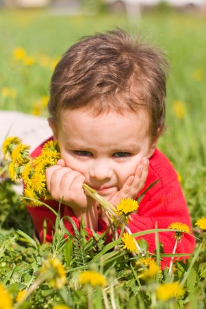 Pensive boy with dandelionsの写真素材
