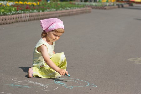 Girl drawing with crayons on the asphaltの写真素材